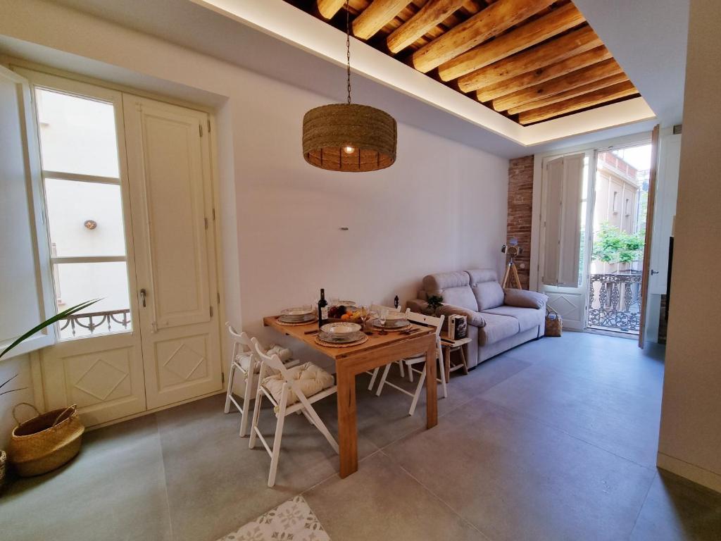 een woonkamer met een tafel en een bank bij Antiquari de Blanes Apartamento rústico modernizado en la Costa Brava in Blanes