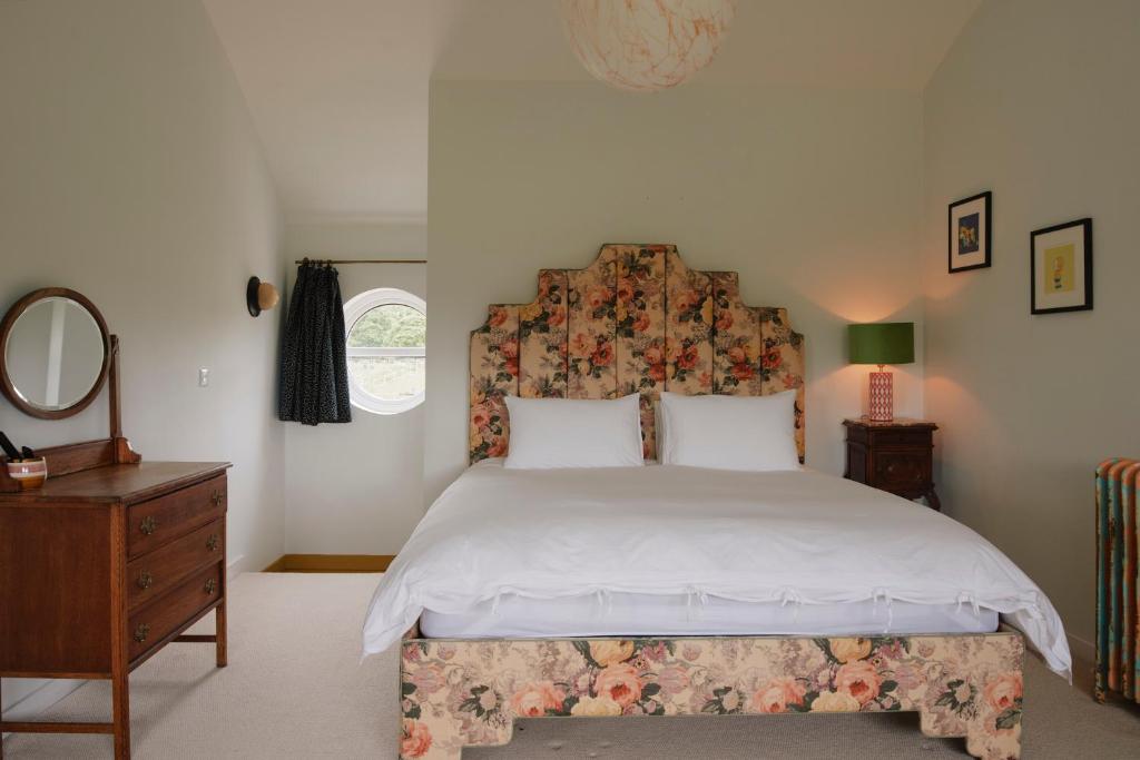 een slaapkamer met een bed, een dressoir en een spiegel bij Molly's Cabin, Countryside Stay in Sutton Bonington