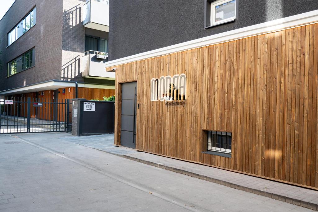 a wooden building with a door on a street at Apartamenty Modra Warszawa in Warsaw