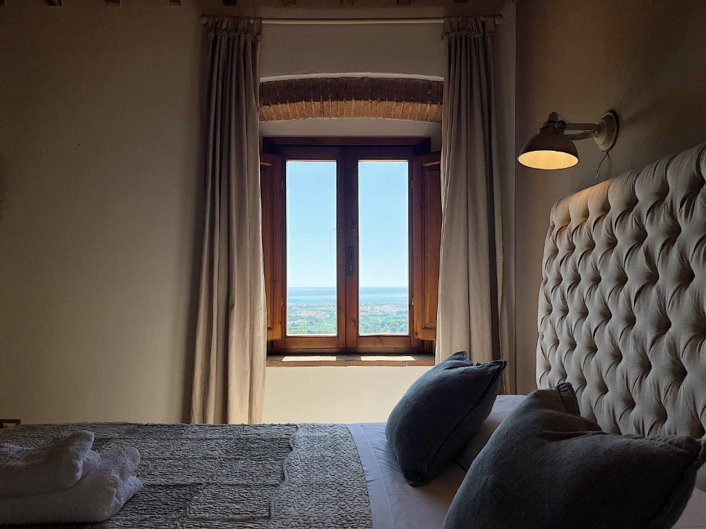 a bedroom with a bed and a window with a view at Bouganville in Rosignano Marittimo