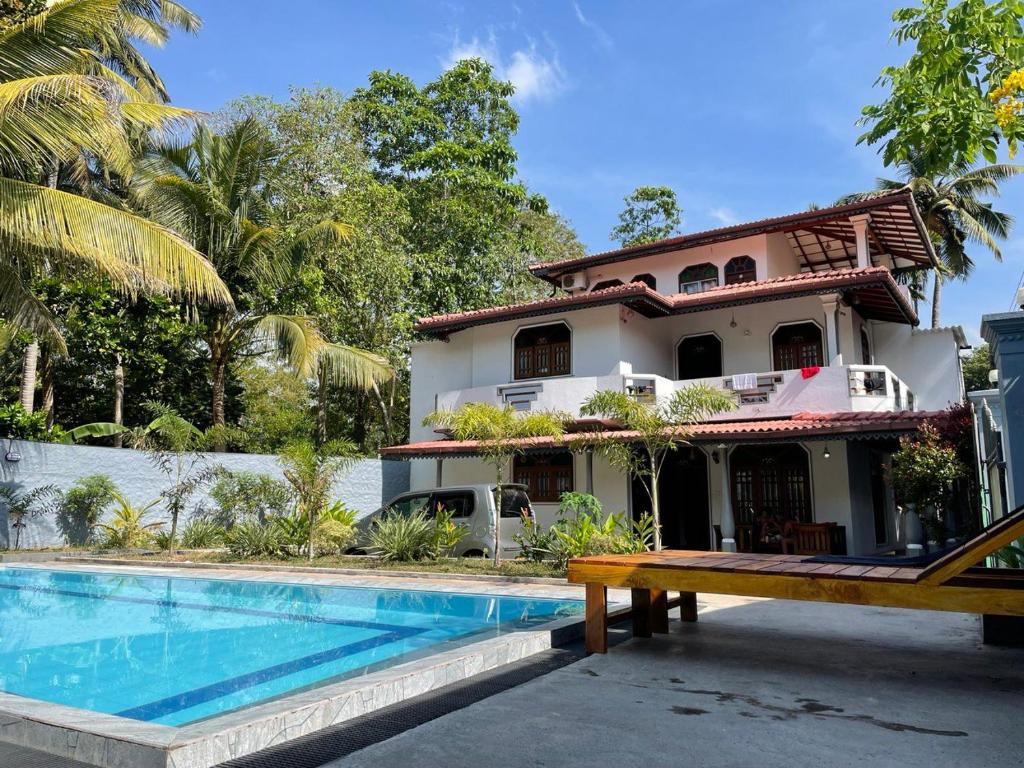una casa con piscina frente a una casa en Ocean Talpe Villa, en Talpe