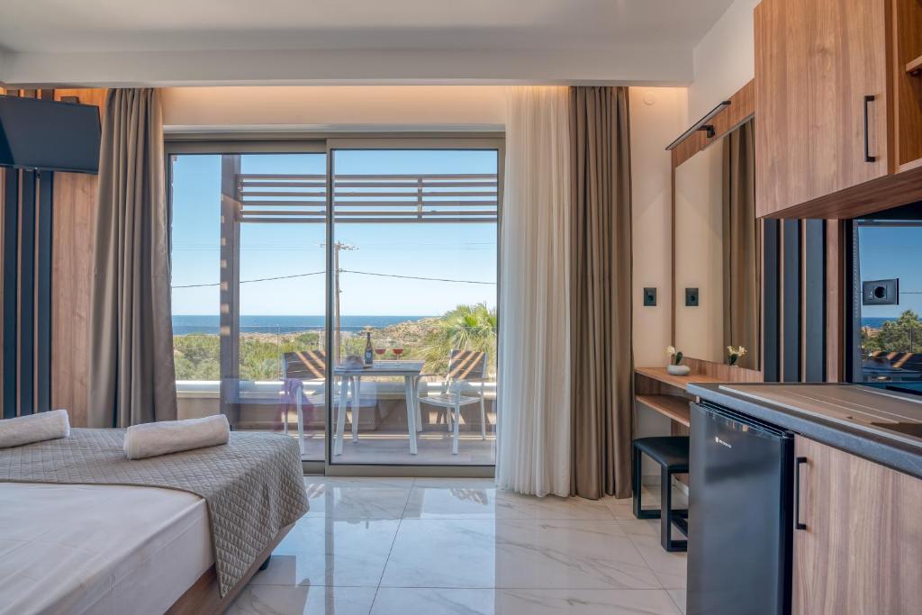 a hotel room with a bed and a kitchen with a view at Xasteria in Elafonisi