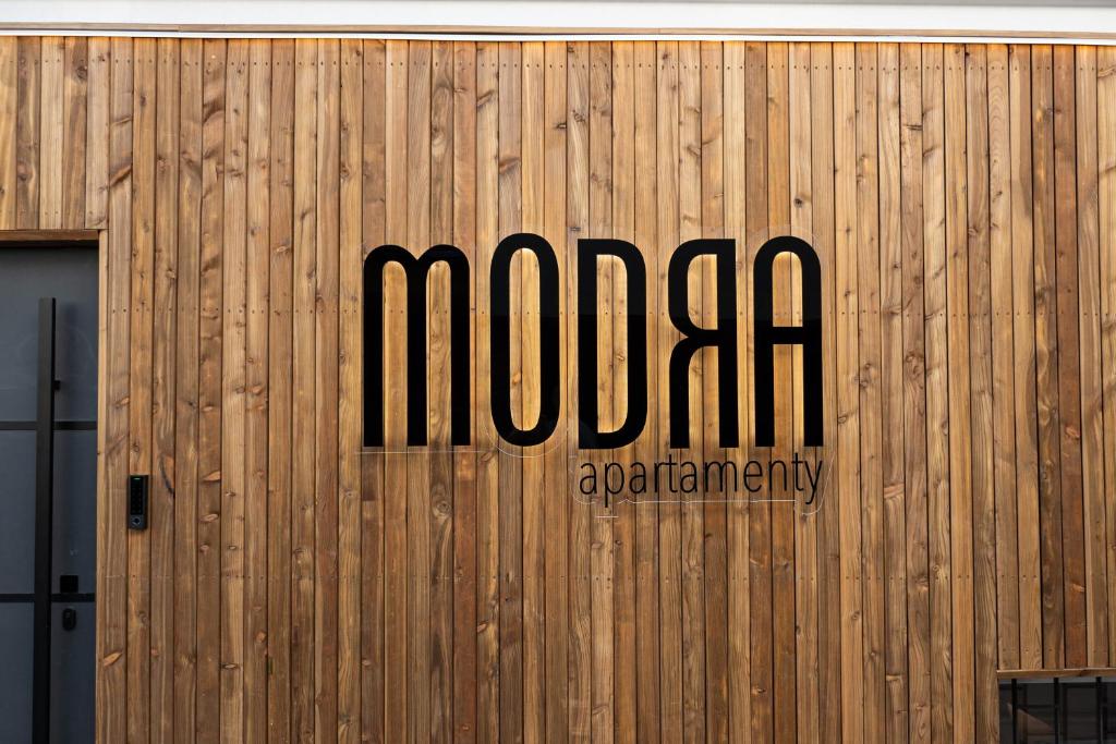 ein Schild an der Seite eines Holzgebäudes in der Unterkunft Apartamenty Modra Warszawa in Warschau