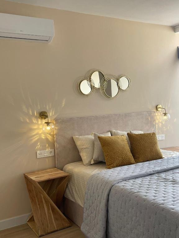 a bedroom with a bed with two mirrors on the wall at Riscal Suits Luxury in Alicante