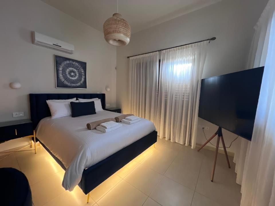 um quarto com uma cama grande e uma televisão de ecrã plano em Matteo Villa Limassol Cyprus em Limassol