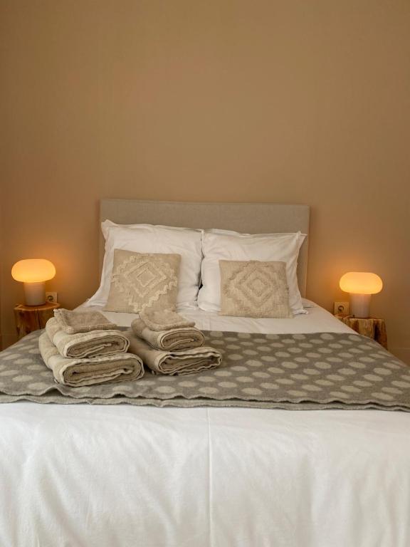 łóżko z białą pościelą i ręcznikami w obiekcie Les chambres de la Villa Oberlin w mieście Beblenheim
