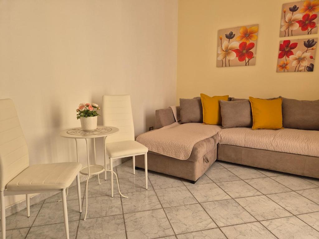 sala de estar con sofá, mesa y sillas en A casa di Nonna, en Catania