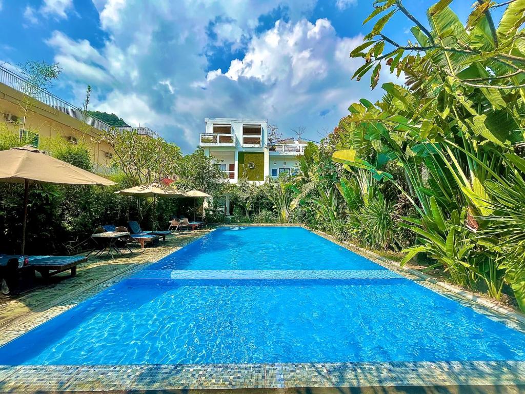 a swimming pool in front of a villa at Diva Lombok Resort in Senggigi 