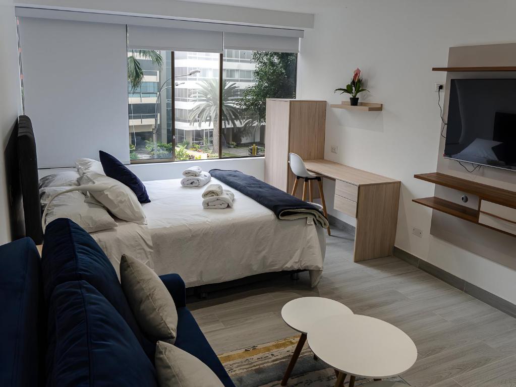 Un dormitorio con una cama, un sofá y un televisor. en Moderno 2BR Center Miraflores- Balta 301, en Lima