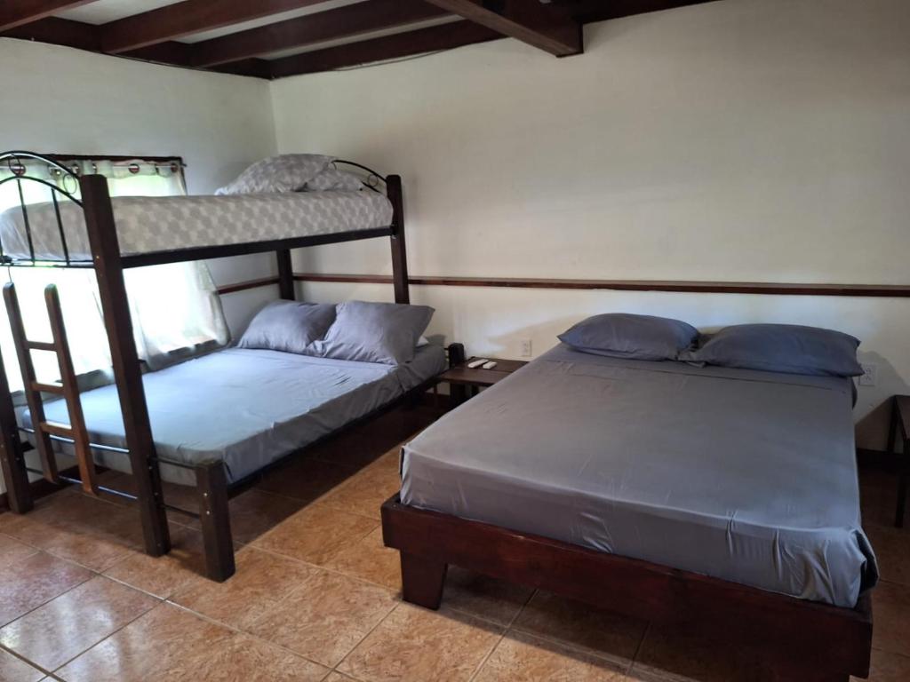 a bedroom with two beds and a bunk bed at Casa Tahoe Home Stay Playa Pita, Costa Rica in Tarcoles