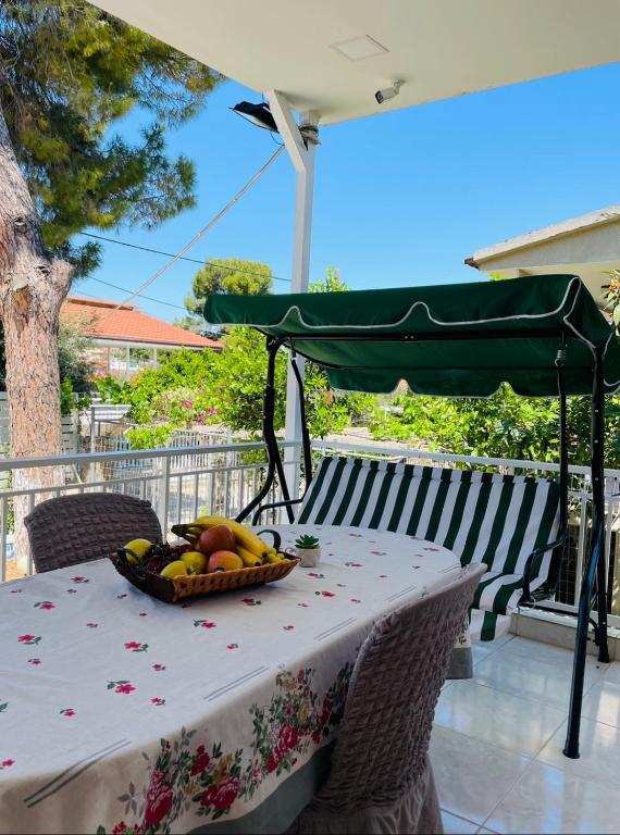 a table with a basket of fruit on it at Your Seaside Escape in Oropos in Skala Oropou