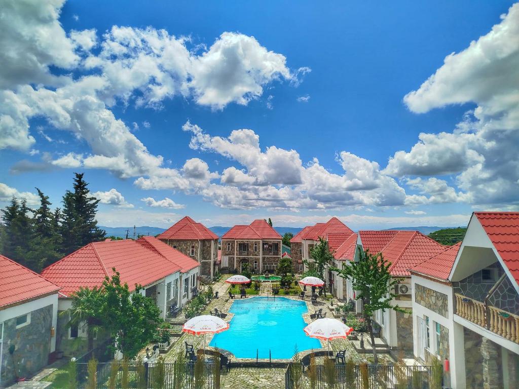 Blick auf ein Resort mit Pool und Sonnenschirmen in der Unterkunft FGarden Hotel Sheki in Şəki