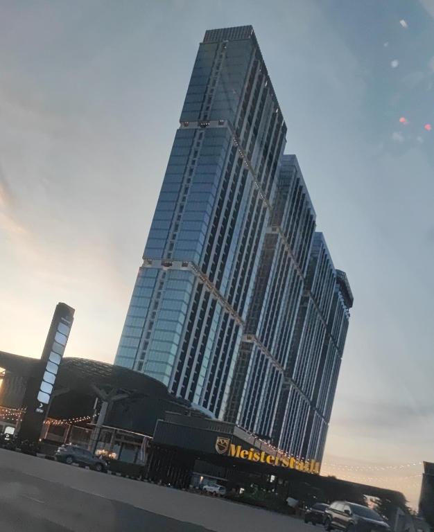 a large building with cars parked in front of it at Serene Studio Pollux Batam Center - High Floor Sea View in Batam Center