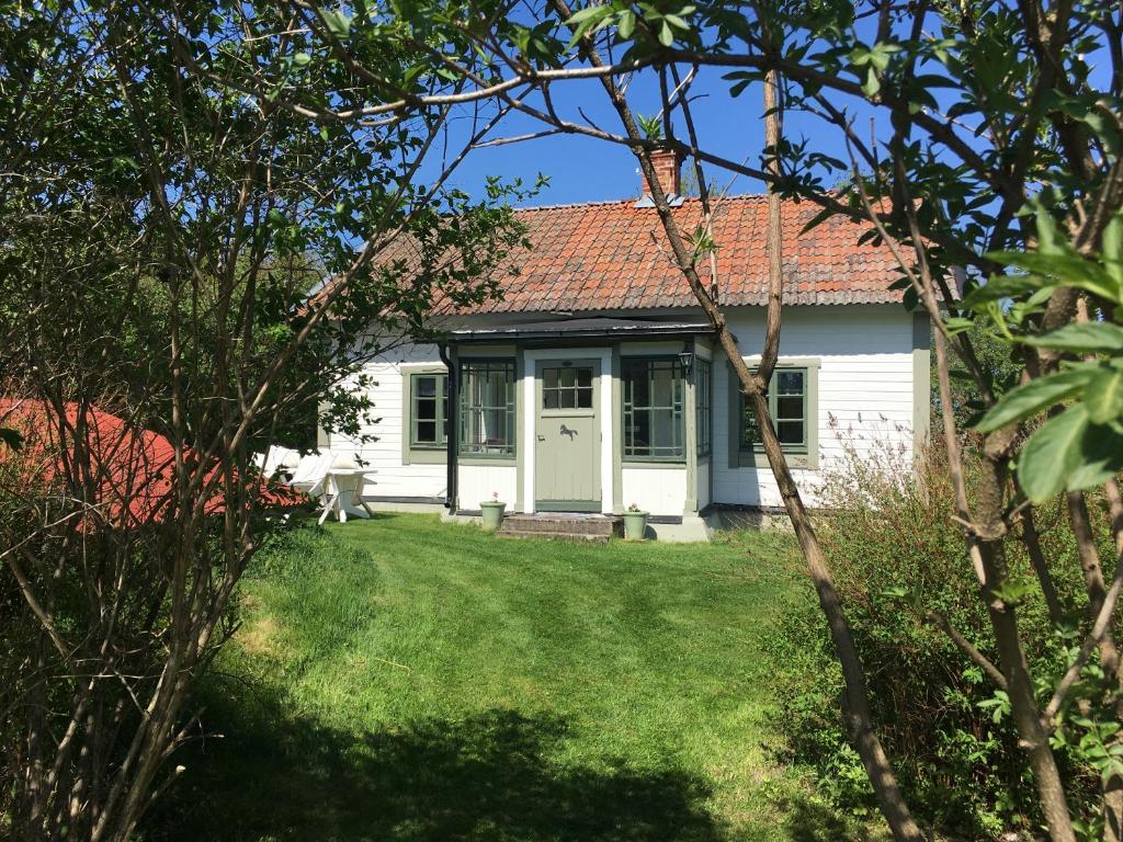 una casa blanca con una puerta blanca y un patio en Enköping Cottage en Enköping