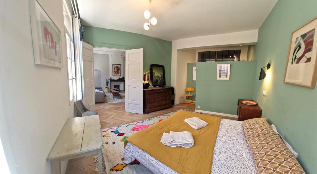 - une chambre avec un lit et des murs verts dans l'établissement Grand appartement Cours Mirabeau, à Aix-en-Provence