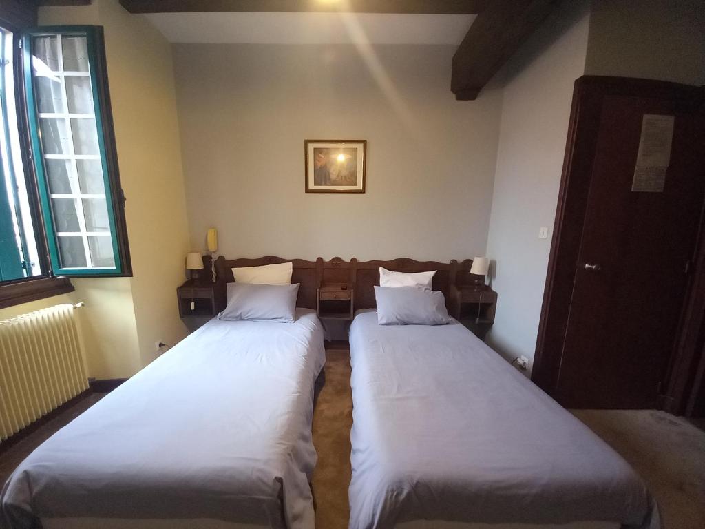 2 camas individuales en una habitación con sofá en Hotel Arocena, en Saint-Pée-sur-Nivelle