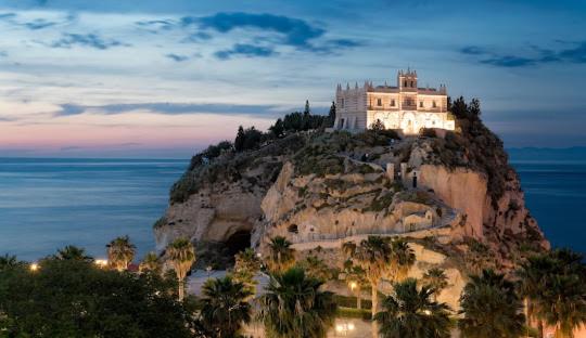 un castillo en la cima de una montaña con el océano en Al Larghetto en Lamezia Terme