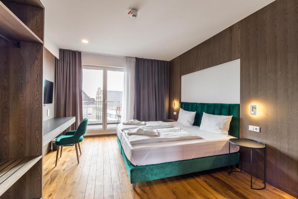 een hotelkamer met een bed en een groot raam bij B-Chill Cologne in Keulen