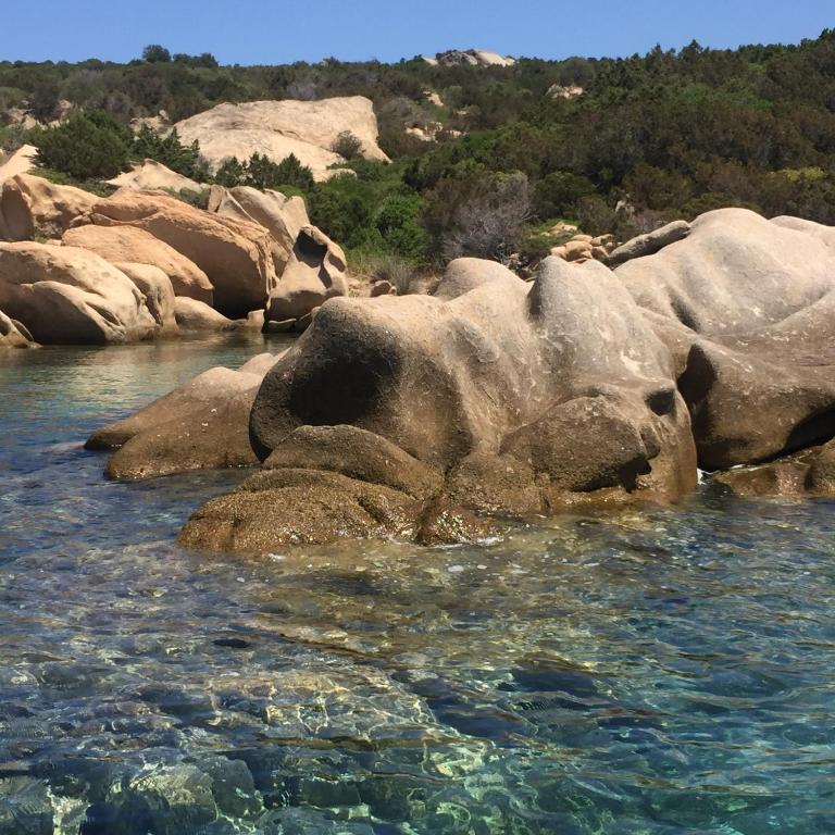 a group of rocks in a body of water at HOTEL al FARO ,SPIAGGIA LA CINTA ,SAN TEODORO in San Teodoro