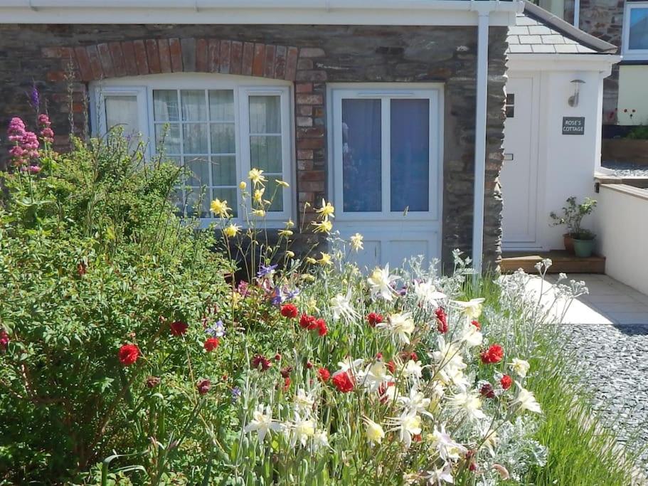 a garden with flowers in front of a house at Rose's Cottage in Gorran Haven
