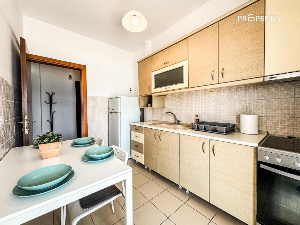 cocina con armarios de madera y encimera blanca en Sea Haven Apartment #Propertly, en Nea Kalikratia