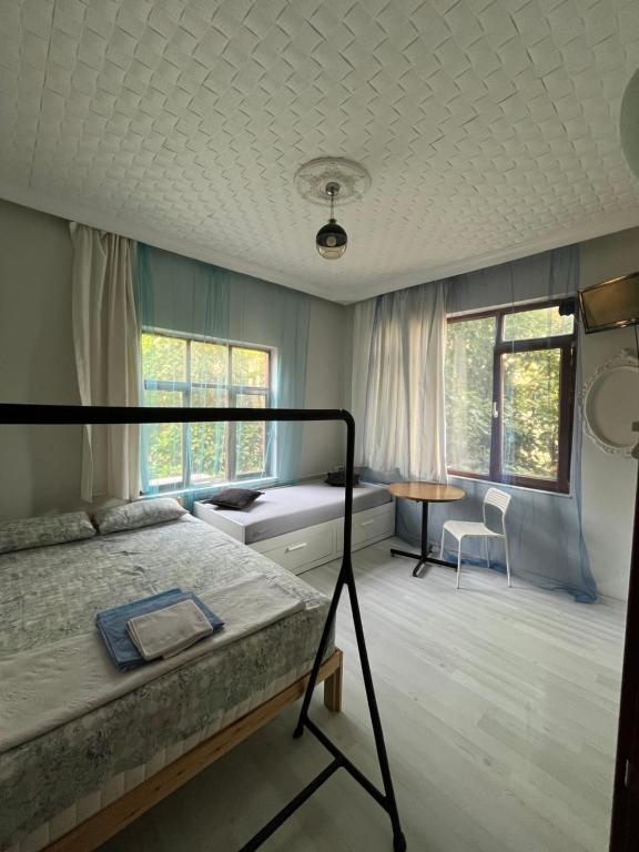 a bedroom with a bed and a table and window at Erkal Pension in Antalya