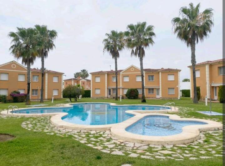 a swimming pool in a yard with palm trees at Casa Laya en Oliva Nova in Oliva