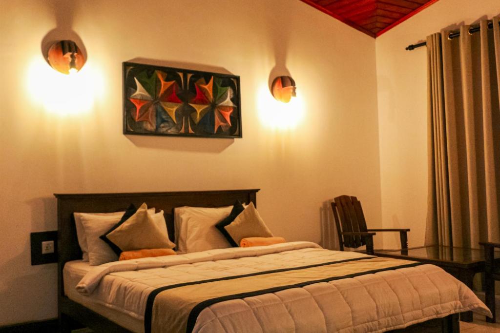 クルネーガラにあるXotic Resort Upper Floorのベッドルーム1室(ベッド1台付)が備わります。壁には絵画が飾られています。