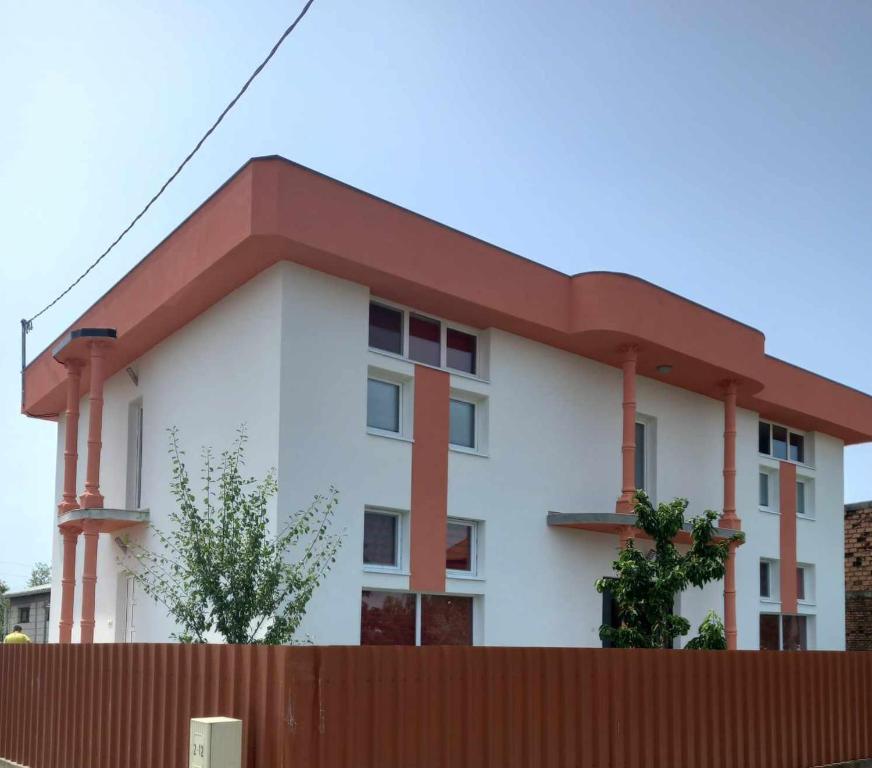 een wit gebouw met een rood dak achter een hek bij Arthur 3 in Brčko