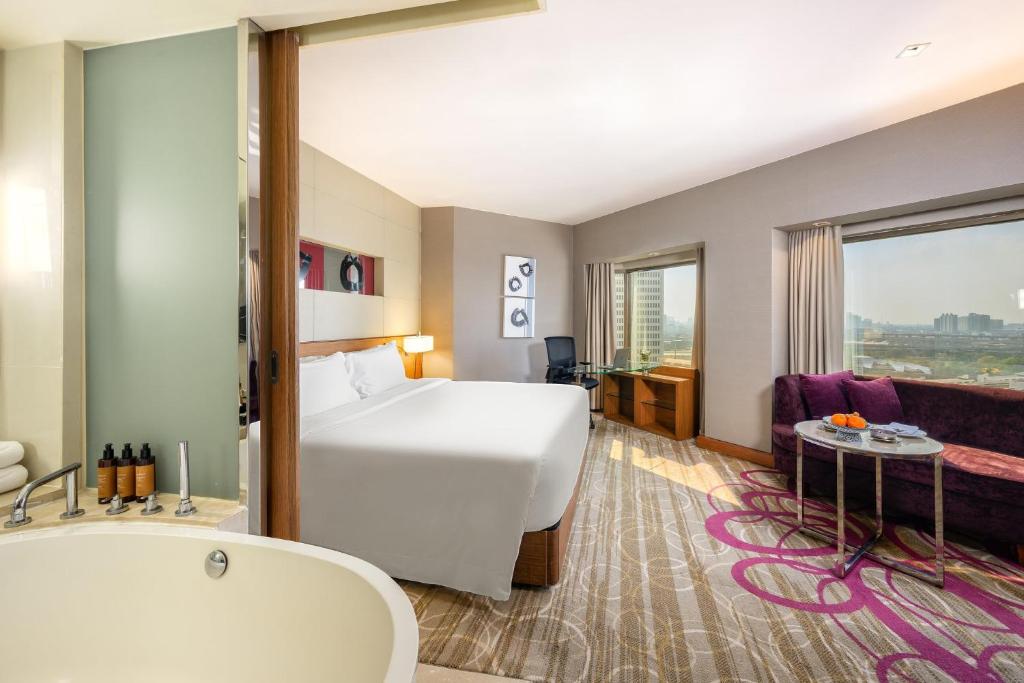 a hotel room with a bed and a bath tub at Centara Grand at Central Plaza Ladprao Bangkok in Bangkok