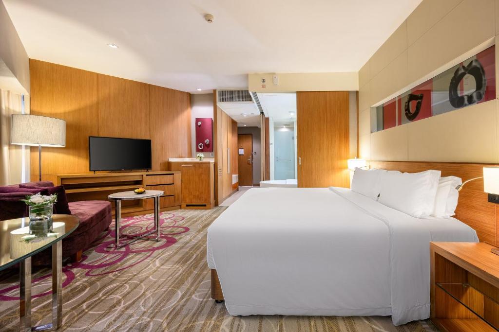 a hotel room with a large bed and a tv at Centara Grand at Central Plaza Ladprao Bangkok in Bangkok