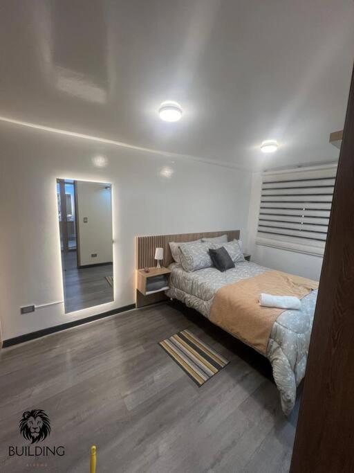 Un dormitorio con una cama grande y un espejo. en Building 70, en Bogotá