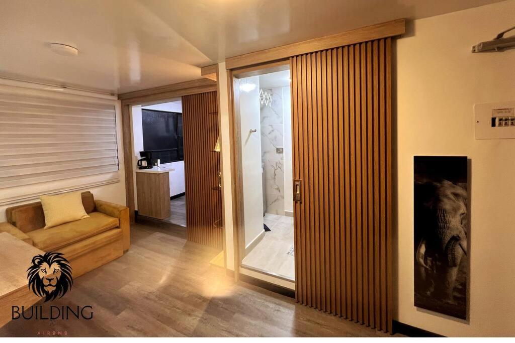 Una sala de estar con un sofá y una puerta corrediza de vidrio. en Building 70, en Bogotá