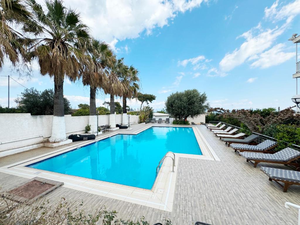 馬蒂的住宿－米爾托酒店，一个带躺椅的游泳池,棕榈树
