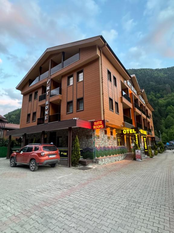 um edifício com um carro estacionado em frente em My Home Uzungöl em Uzungol