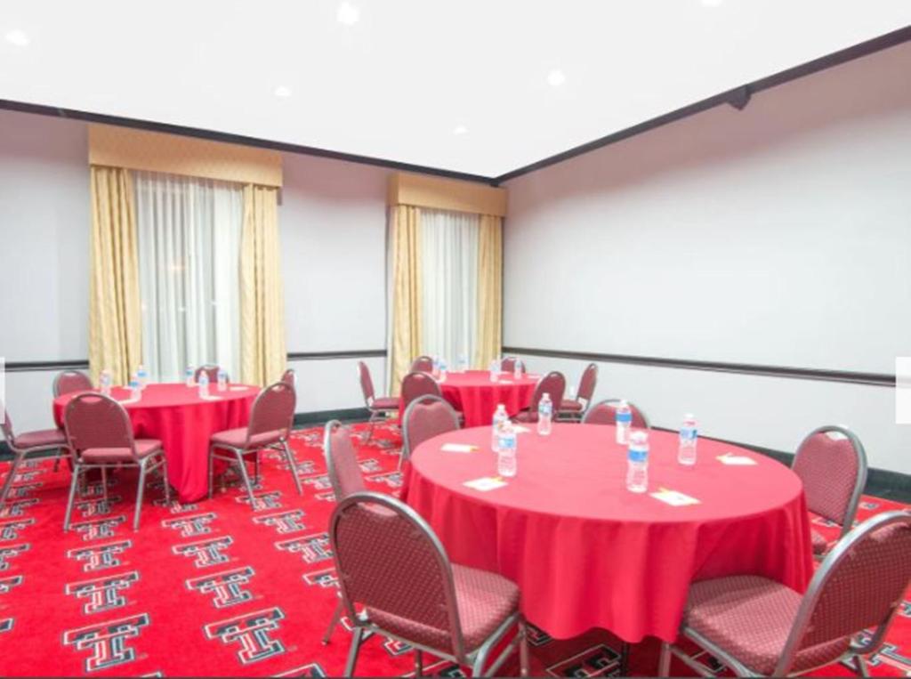 a conference room with red tables and chairs at Days Inn by Wyndham Lubbock South in Lubbock