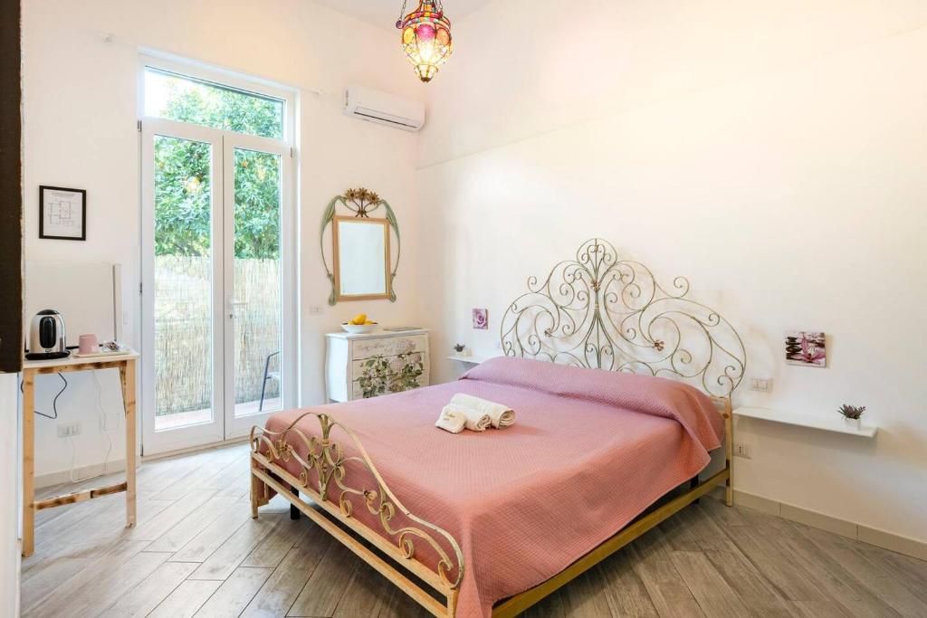 a bedroom with a bed with a pink blanket at Beatrice Room Bed&Breakfast in Sant'Agnello