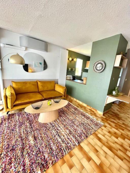 un salon avec un canapé et un tapis dans l'établissement Le Nid Ensoleillé - Centre port, au Cap d'Agde