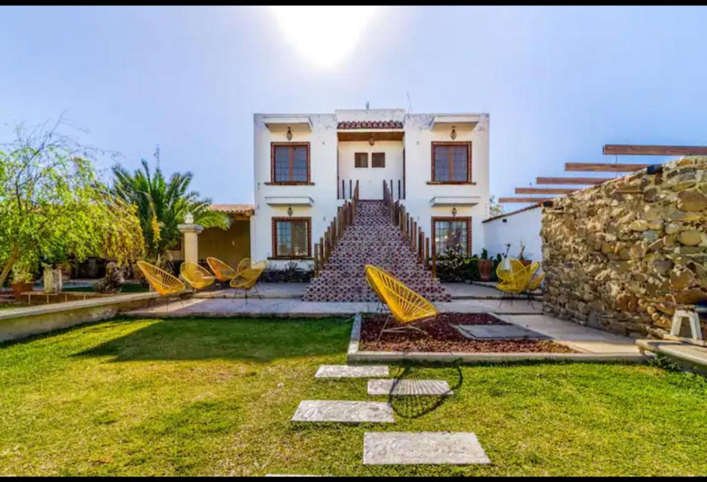 ein Haus mit gelben Stühlen im Garten in der Unterkunft Villa Isabela 10 Sleeps - Pool - Huge garden in Cuyutlán