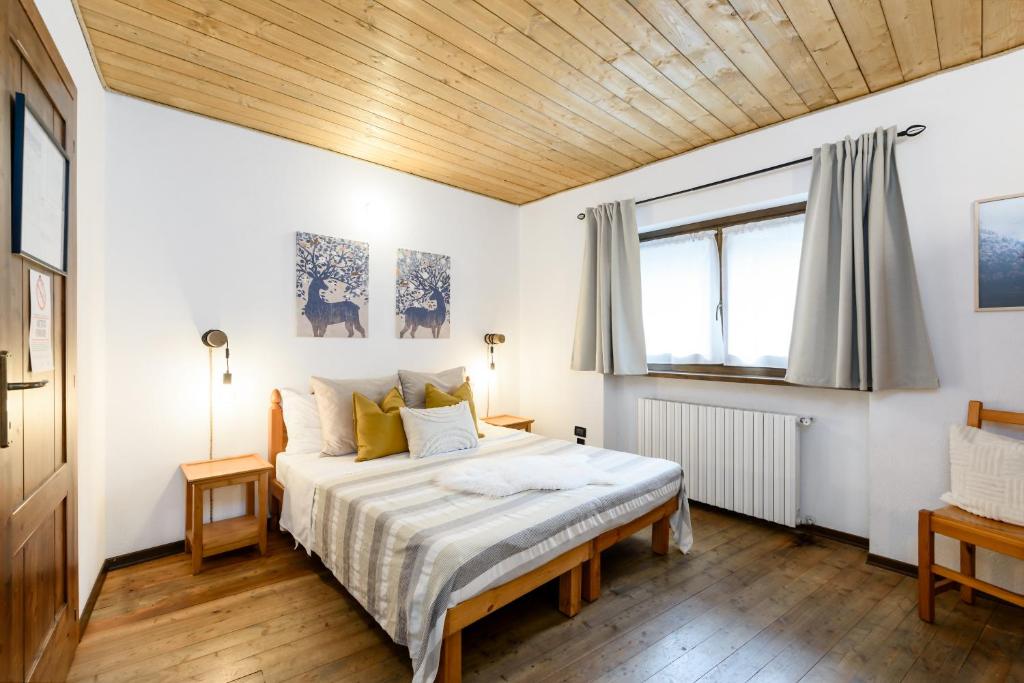 1 dormitorio con 1 cama con techo de madera en Rifugio Escursionistico La Ruà en Macra