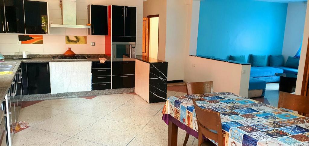 a kitchen with a table and a blue couch at Vivre un experience inoubliable in Casablanca