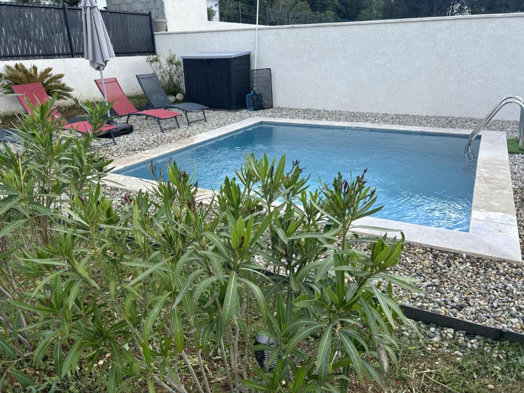 ein Schwimmbad in einem Hof mit einigen Pflanzen in der Unterkunft vacances en Ardéche "maison Chauvet" in Vallon-Pont-dʼArc