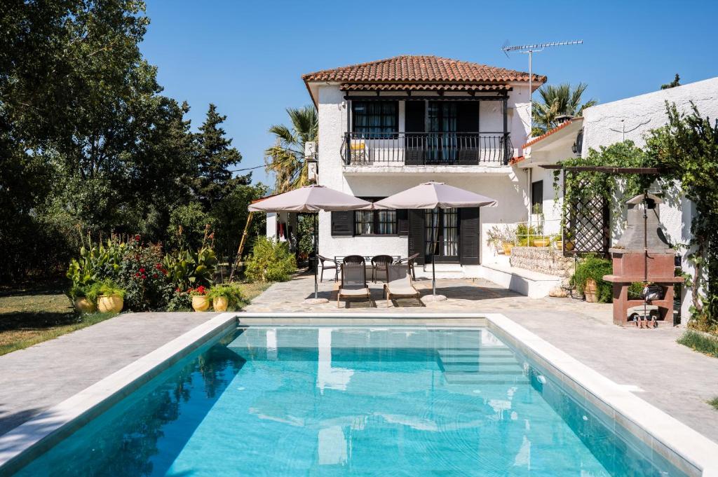 a house with a swimming pool in front of a house at Mansion Domenica in Sarakinádhon