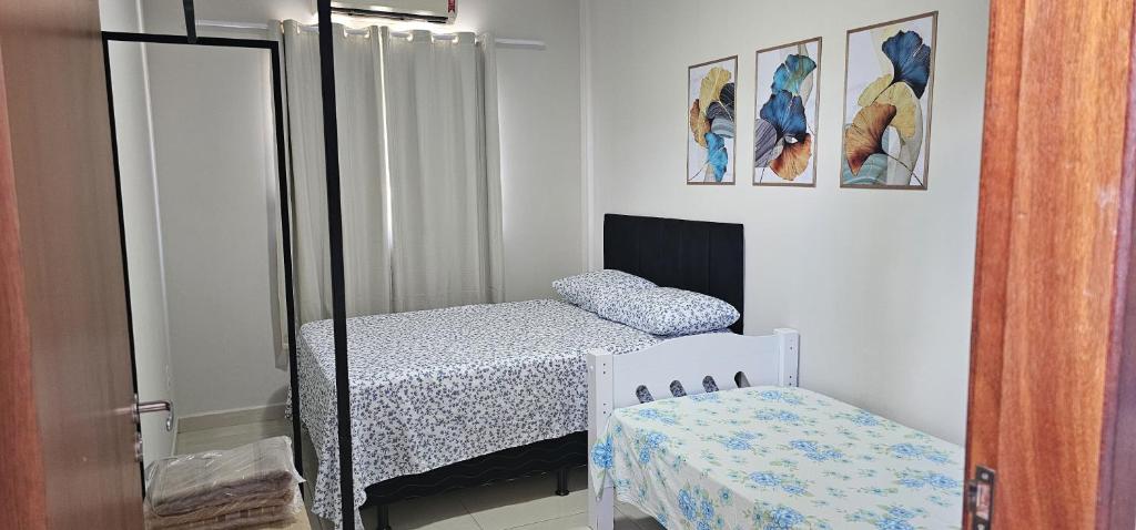 1 dormitorio con 2 camas individuales y espejo en Casa Duplex Alegria - Ar e Garagem Privativa en Bom Jesus da Lapa