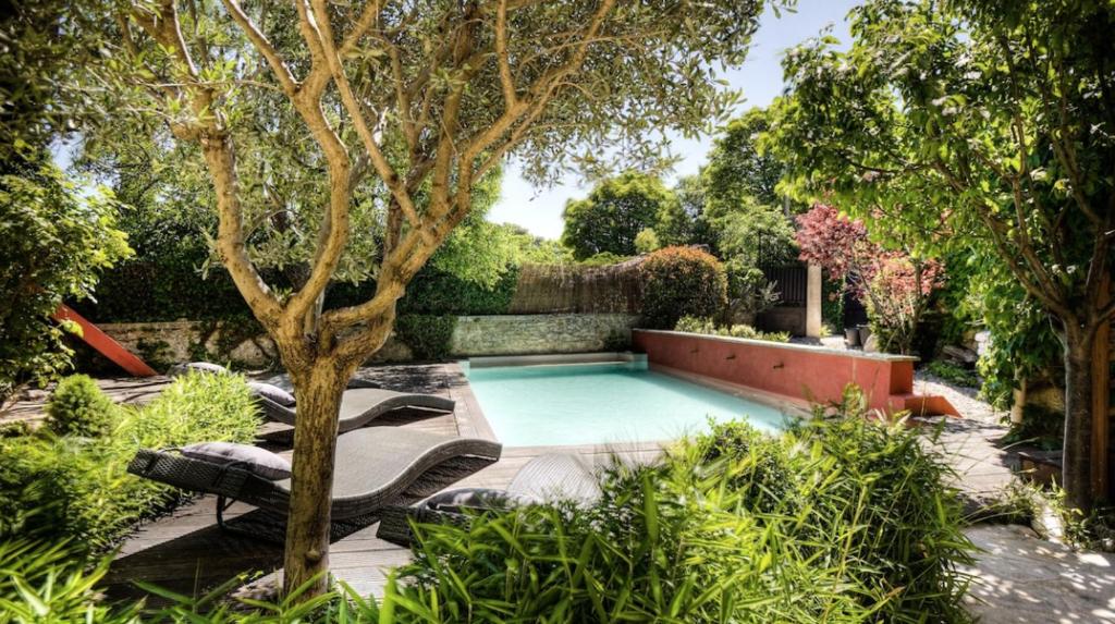 une piscine au milieu d'un jardin dans l'établissement ELIA HOUSE, à Goult