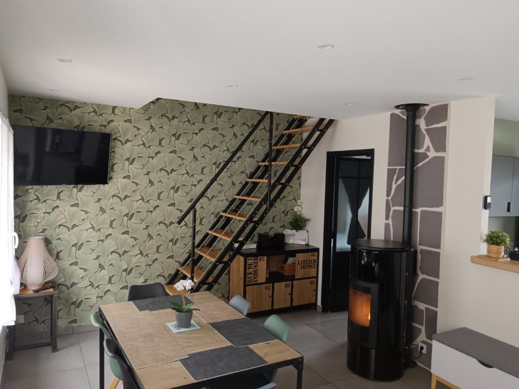 een woonkamer met een trap, een tafel en een open haard bij Le petit poucet in La Bourboule