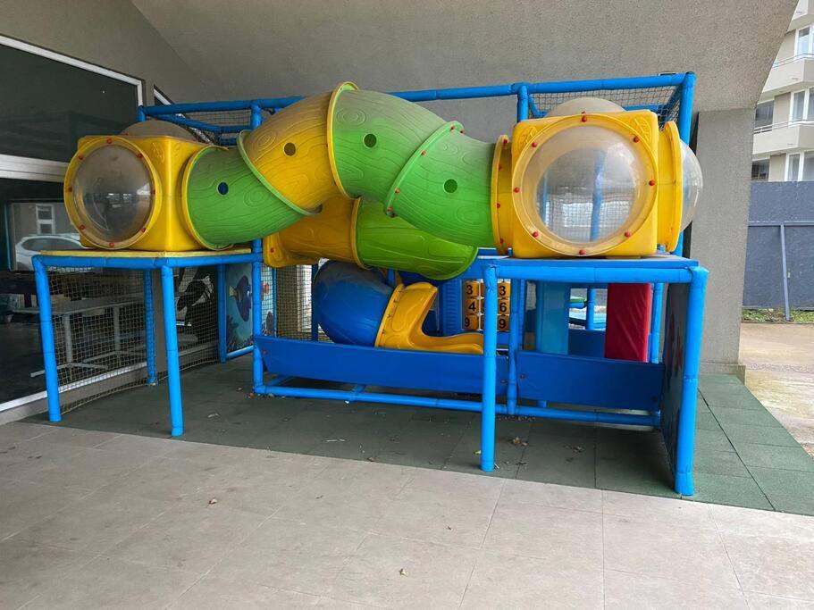 a playground with a slide in front of a building at Cómodo y agradable departamento, 2 habitaciones in Llanquihue