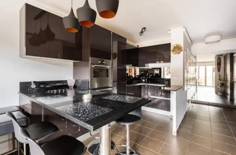 a kitchen with a black counter top and black chairs at Carpe Diem in Beaulieu-sur-Mer
