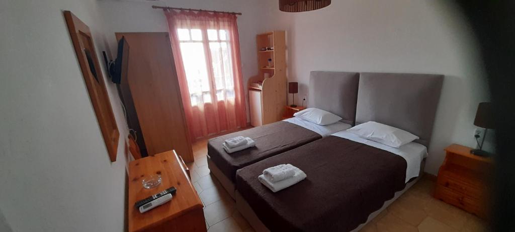 - une chambre avec un lit et 2 serviettes dans l'établissement Pension Selenti, à Tinos