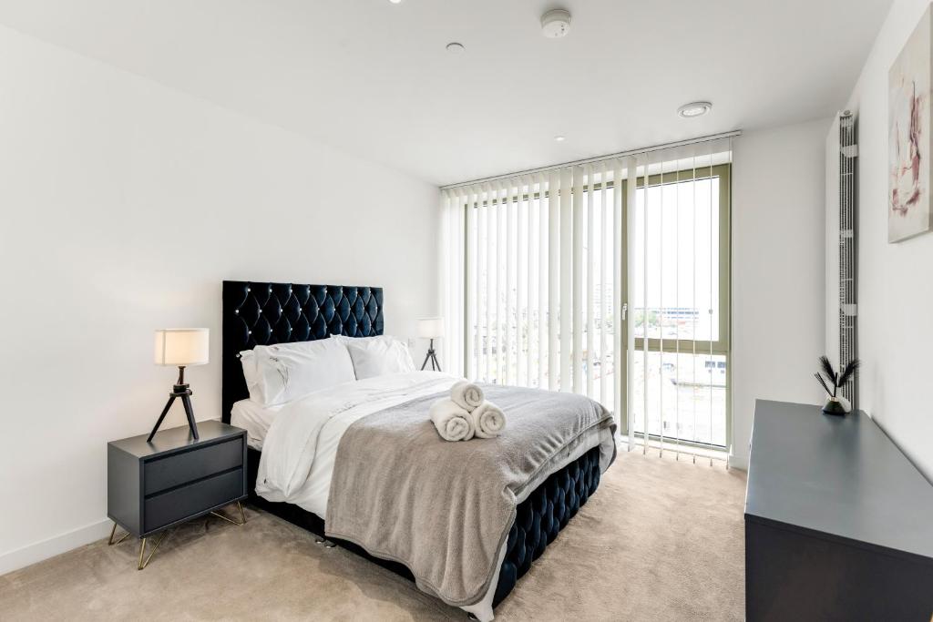 a bedroom with a large bed and a large window at Khayat Homes - The Khalifa - One Bed Luxury APt in London